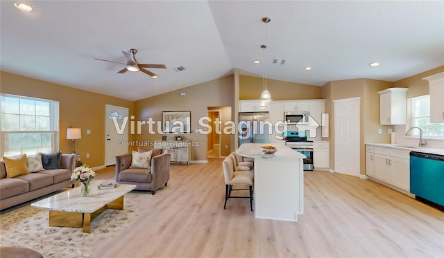 kitchen featuring hanging light fixtures, white cabinetry, appliances with stainless steel finishes, and a center island