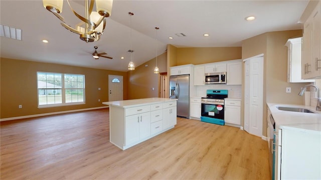 kitchen featuring sink, decorative light fixtures, a kitchen island, stainless steel appliances, and white cabinets