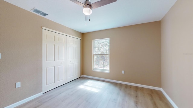 unfurnished bedroom with a closet, ceiling fan, and light wood-type flooring