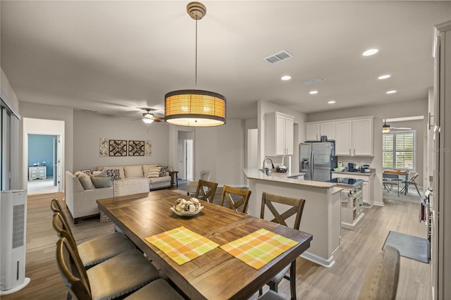 dining room featuring ceiling fan, light hardwood / wood-style floors, and sink