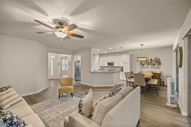 living room featuring ceiling fan and light hardwood / wood-style flooring