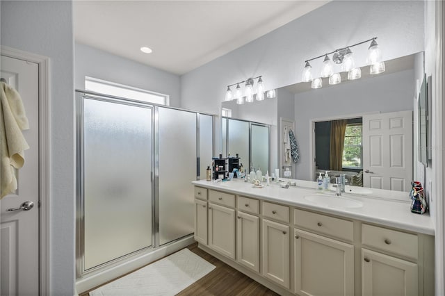 bathroom with wood-type flooring, walk in shower, and vanity