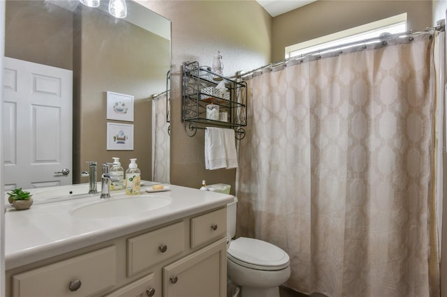 bathroom featuring curtained shower, toilet, and vanity