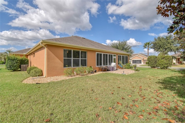 rear view of property featuring central AC unit, a lawn, and a patio