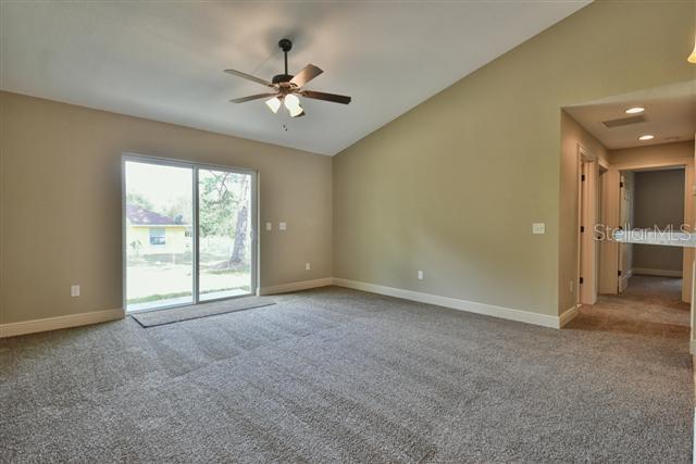 empty room with carpet, ceiling fan, and lofted ceiling