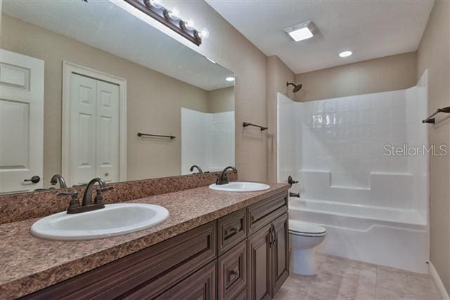 full bathroom with tile patterned flooring, vanity, shower / bathtub combination, and toilet