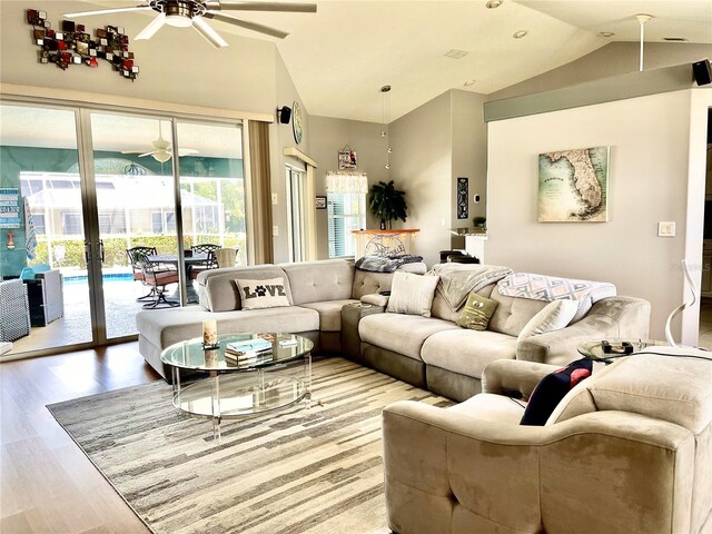 living room with ceiling fan, hardwood / wood-style floors, and lofted ceiling