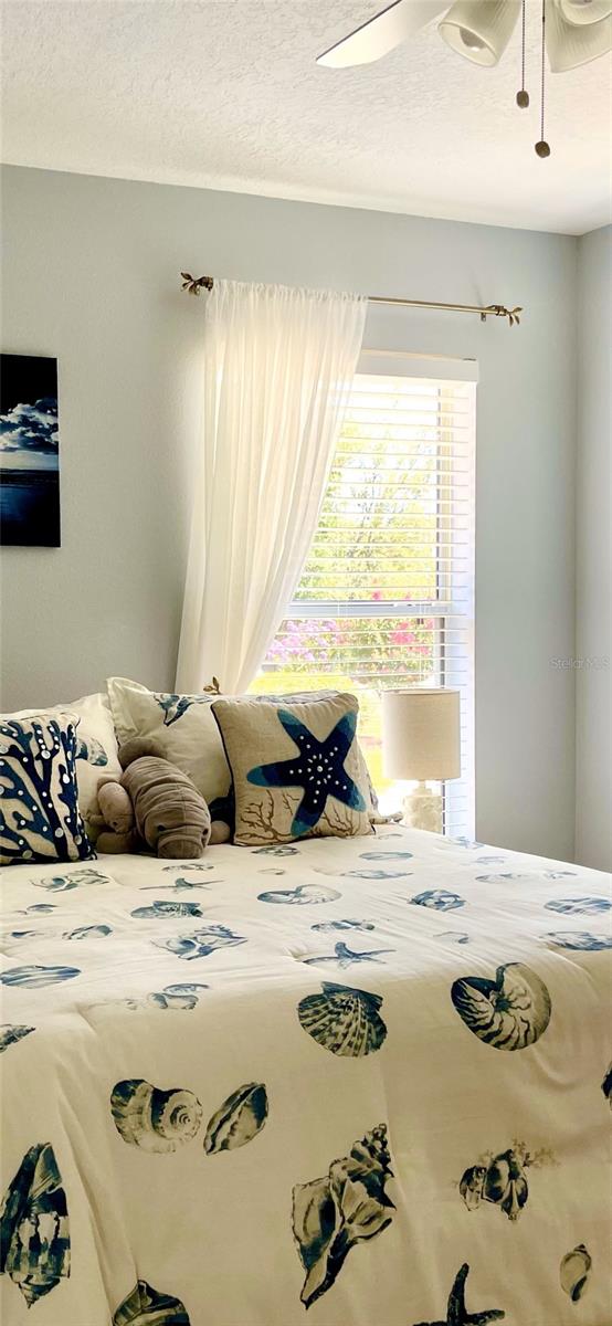 unfurnished bedroom featuring ceiling fan and a textured ceiling