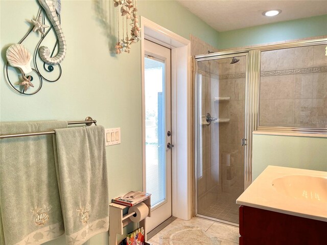 bathroom featuring tile patterned flooring, vanity, and an enclosed shower