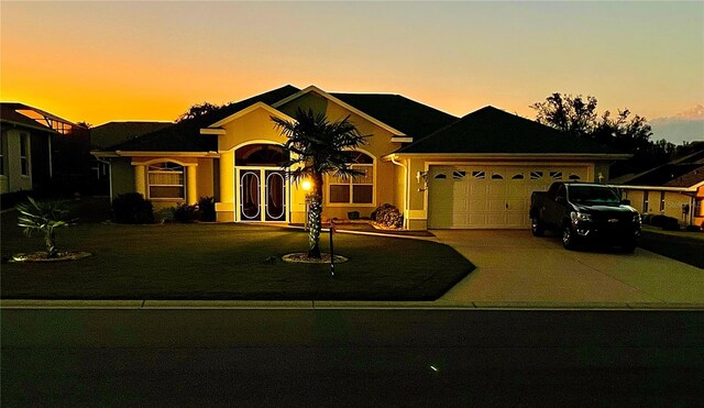 ranch-style home with a yard and a garage