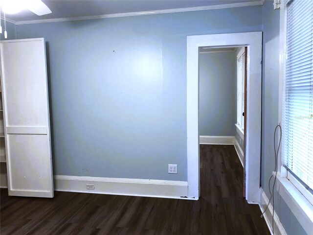 empty room featuring crown molding, dark hardwood / wood-style floors, and ceiling fan