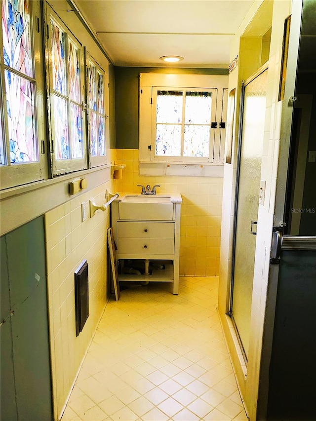 interior space featuring sink, tile walls, and light tile patterned floors