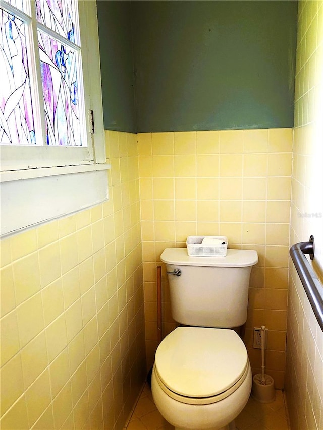 bathroom with tile patterned flooring, toilet, and tile walls