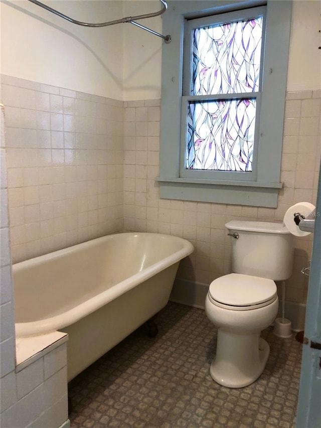 bathroom with tile walls, toilet, and tile patterned flooring