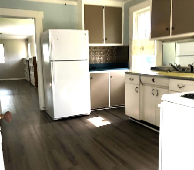 kitchen featuring white cabinetry, dark hardwood / wood-style flooring, white appliances, and backsplash