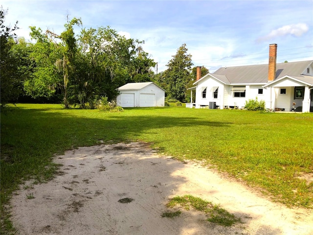 view of yard featuring a garage and an outbuilding