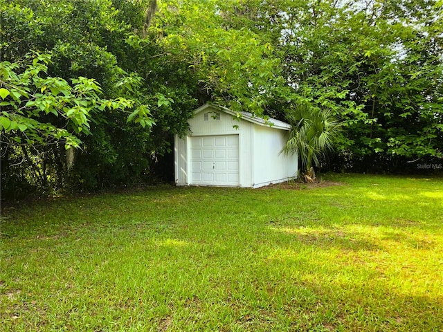 view of yard featuring a garage and an outbuilding