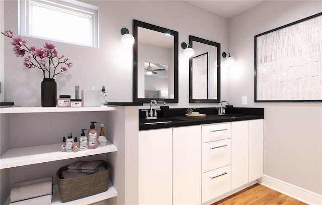 bathroom with hardwood / wood-style flooring, oversized vanity, and dual sinks