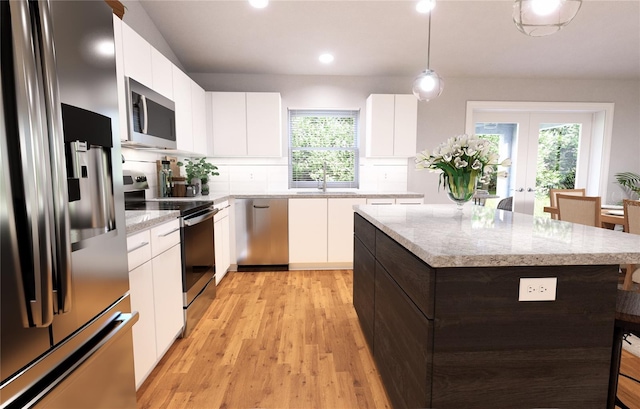 kitchen with decorative light fixtures, stainless steel appliances, tasteful backsplash, a breakfast bar area, and white cabinets