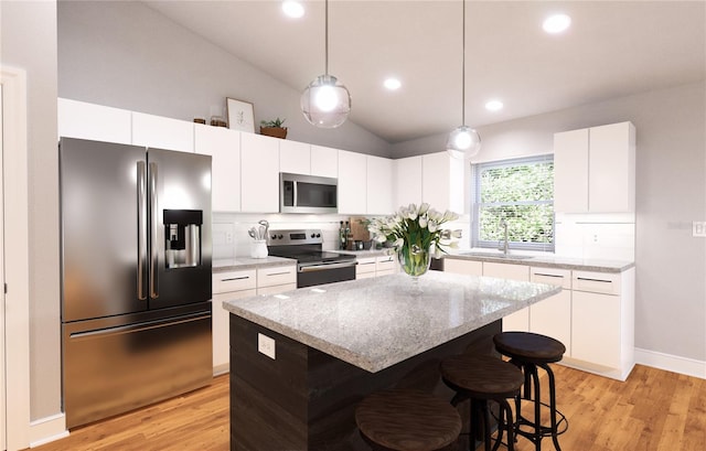 kitchen with appliances with stainless steel finishes, light wood-type flooring, lofted ceiling, and a kitchen island