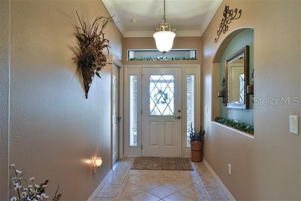 foyer featuring light tile patterned floors and ornamental molding