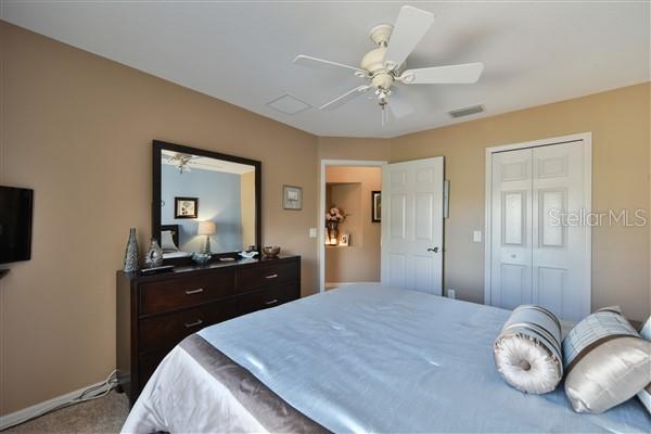 carpeted bedroom featuring ceiling fan and a closet