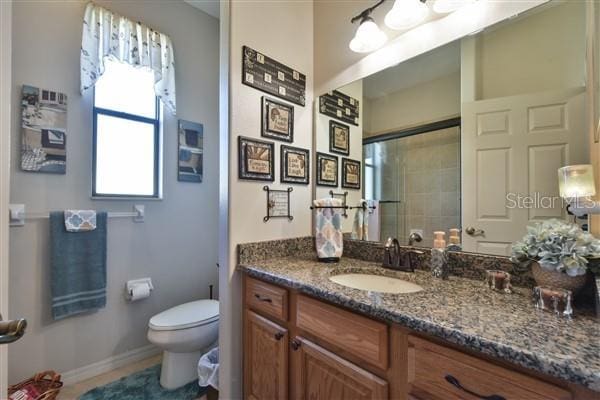 bathroom featuring vanity, toilet, and walk in shower