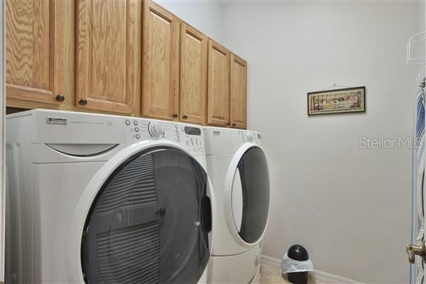 laundry area featuring separate washer and dryer and cabinets