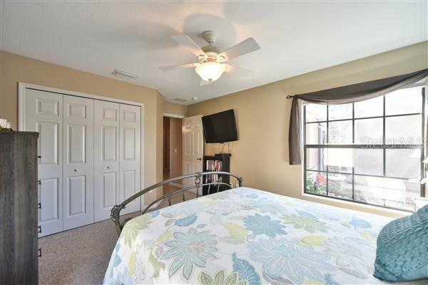 bedroom with carpet, ceiling fan, and a closet