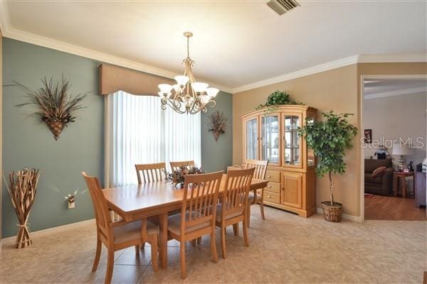 dining space with crown molding and a notable chandelier