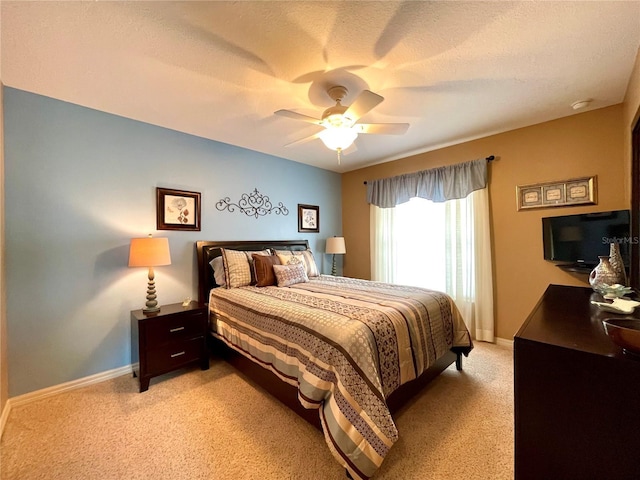 bedroom featuring ceiling fan, light carpet, and a textured ceiling