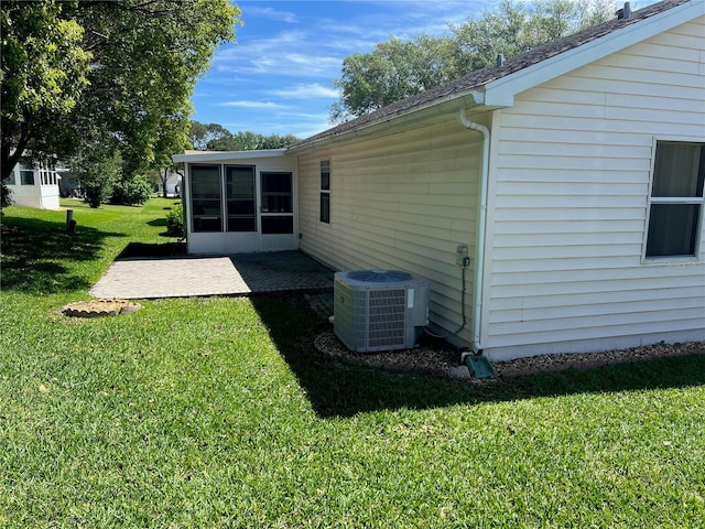 view of yard with central AC and a sunroom