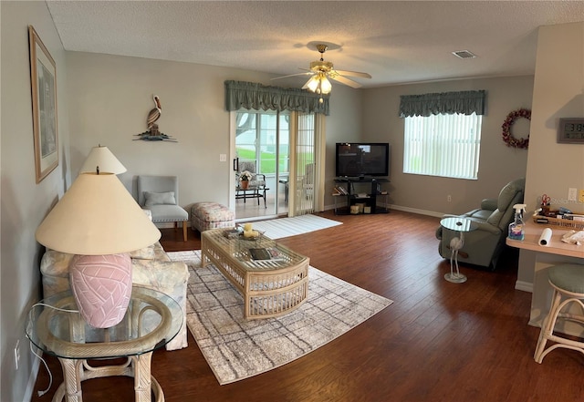 living room with hardwood / wood-style floors, ceiling fan, and a textured ceiling