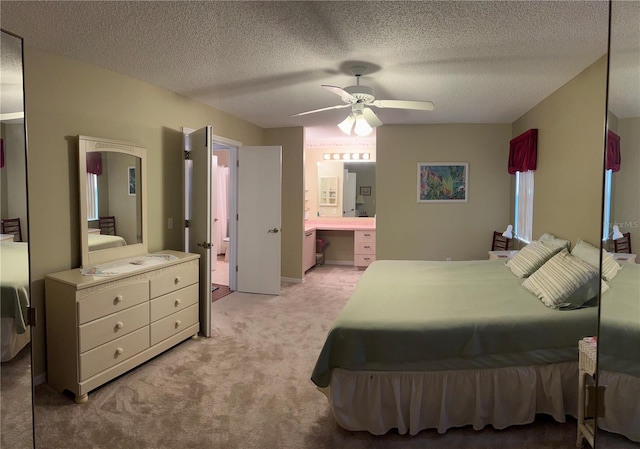 bedroom featuring light carpet, connected bathroom, ceiling fan, and a textured ceiling