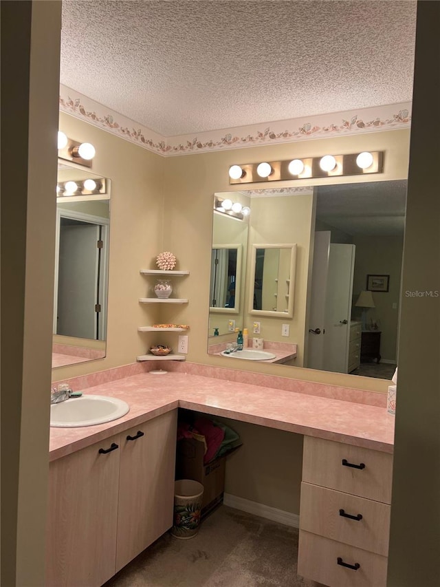 bathroom featuring vanity with extensive cabinet space and a textured ceiling