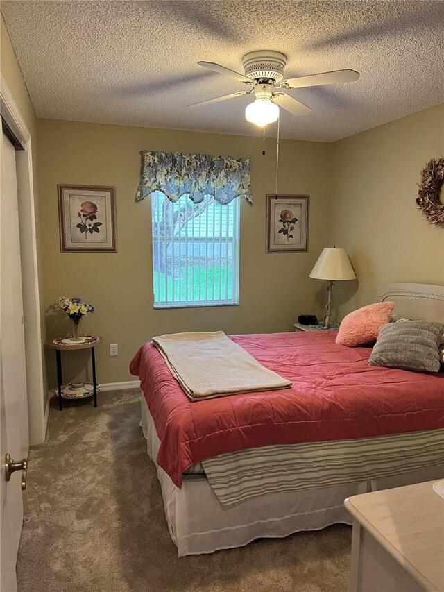 carpeted bedroom with ceiling fan and a textured ceiling