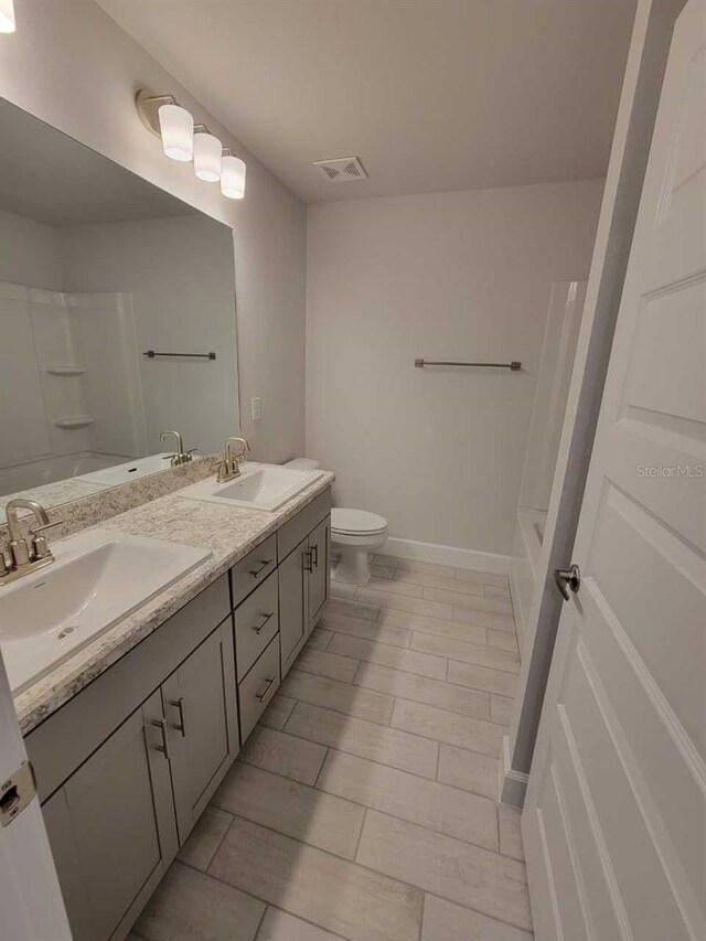 bathroom with hardwood / wood-style flooring, vanity, and toilet