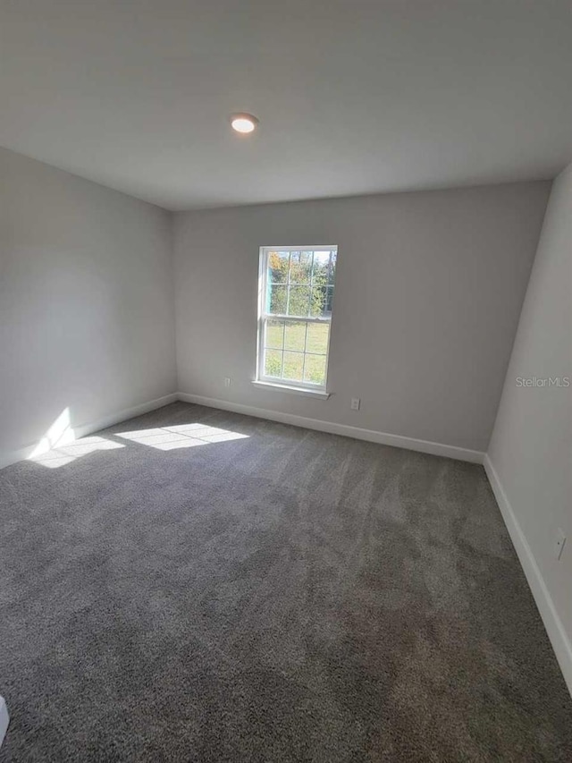 empty room with dark colored carpet