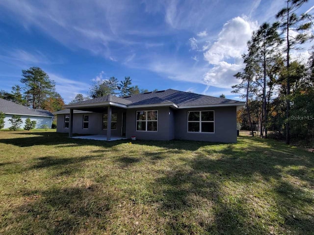 5243 SW 106th St, Ocala, FL 34476 - back of house with stucco siding, a patio area, and a lawn