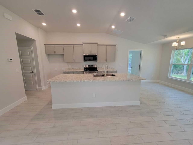5243 SW 106th St, Ocala, FL 34476 - kitchen featuring a sink, appliances with stainless steel finishes, gray cabinets, vaulted ceiling, and an island with sink