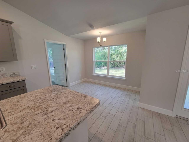 kitchen featuring pendant lighting, gray cabinets, light hardwood / wood-style flooring, and a notable chandelier