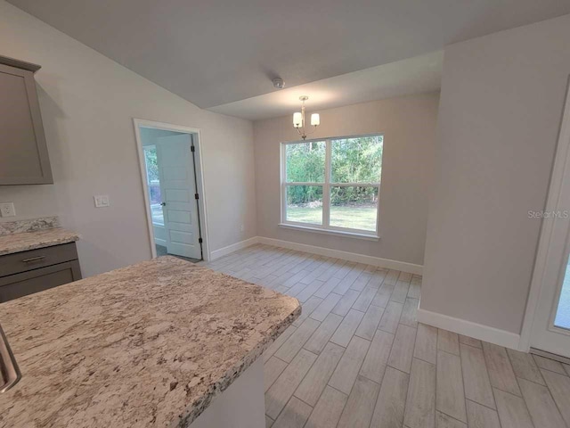5243 SW 106th St, Ocala, FL 34476 - kitchen featuring baseboards, gray cabinets, light wood-type flooring, and lofted ceiling