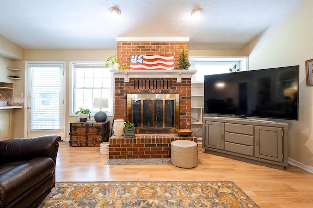 living room with a fireplace and light wood-type flooring