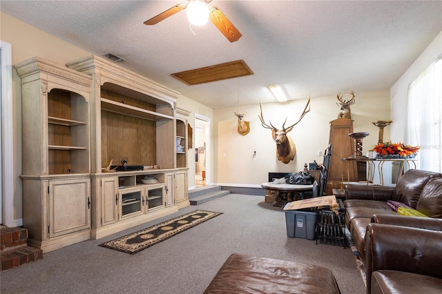 living room with carpet flooring, a textured ceiling, and ceiling fan