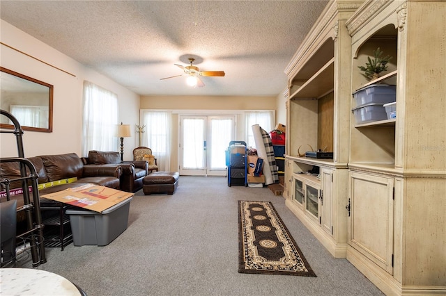 living room with carpet, ceiling fan, a textured ceiling, and french doors