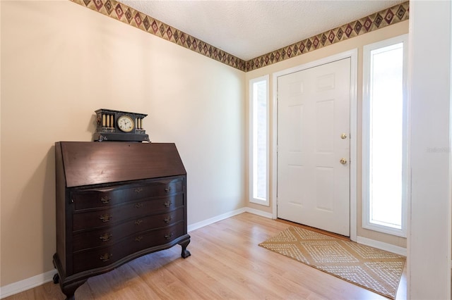 entrance foyer featuring a textured ceiling and light wood-type flooring