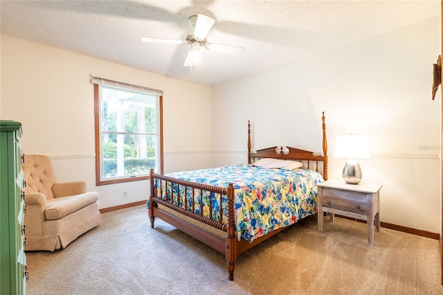 carpeted bedroom with ceiling fan and a textured ceiling