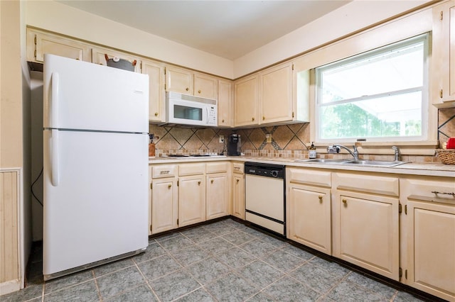 kitchen with backsplash, white appliances, and sink