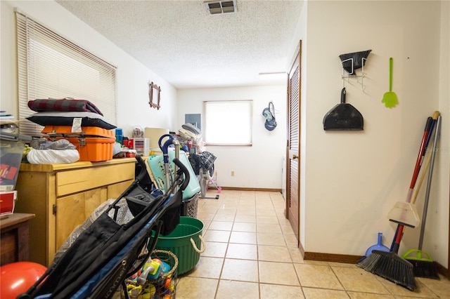 laundry area featuring light tile patterned floors and a textured ceiling