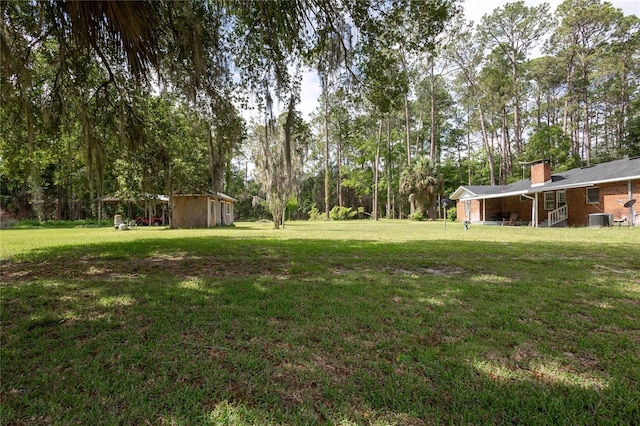 view of yard featuring an outdoor structure and central air condition unit